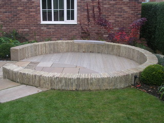 circular seating garden patio stone wall laid on edge stone paving timber decking contemporary garden design