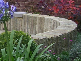 circular seating garden patio stone wall laid on edge agapanthus red purple cotinus autumn colour plants