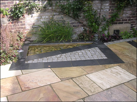modern square pond with setts and slate paving cobbles triangle water feature stone paving contemporary garden design