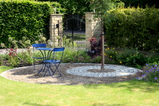 circular seating area of setts and gravel with a tree
