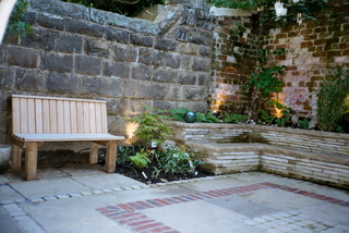 courtyard garden landscaping with built in seating and simple timber seat brick paving detail in stone paving and setts at Otley Yorkshire