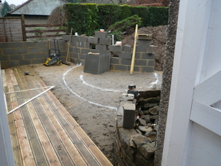 marking out for landscaping white spray paint on patio area garden construction paving slabs and breeze block wall decking