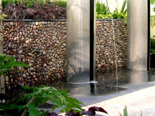 RHS Tatton show garden cobble and stone paving with slate detail, steel water feature and pebble wall