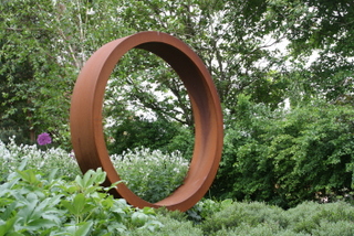 garden steel ring sculpture floating above ground cover planting contemporary garden design