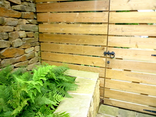 horizontal timber fence with wooden side gate modern gate ferns and stone wall