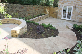 sloping courtyard with stone paving curved stone steps circular seating area patio doors new planting yorkshire mews