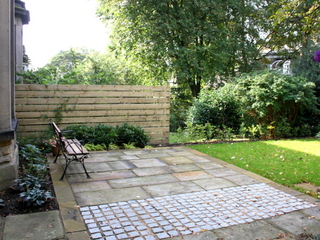setts and yorkshire sandstone paving in patio timber slatted fence for privacy